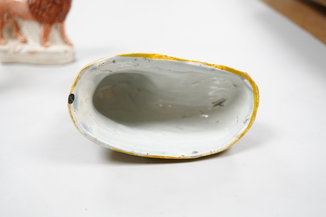 A rare Staffordshire Pearlware model of a recumbent lion, c.1810, and three Staffordshire pottery models of lions, mid 19th century, largest 11cm wide